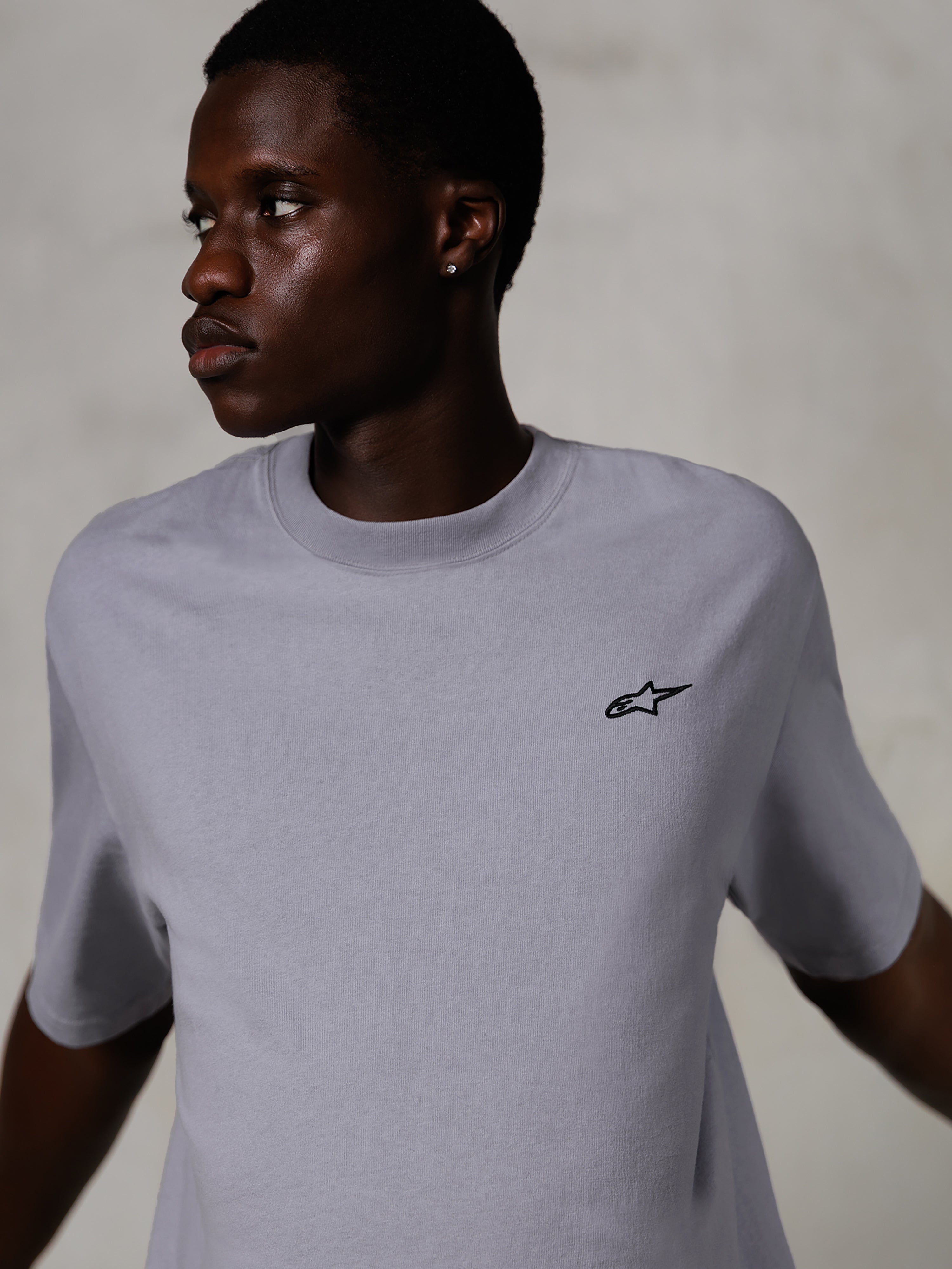Mannequin portant le T-shirt Alpinestars Essentials Ageless SS, t-shirt à manches courtes, argenté, avec un petit logo noir sur la poitrine, coupe décontractée, design streetwear épuré et minimaliste