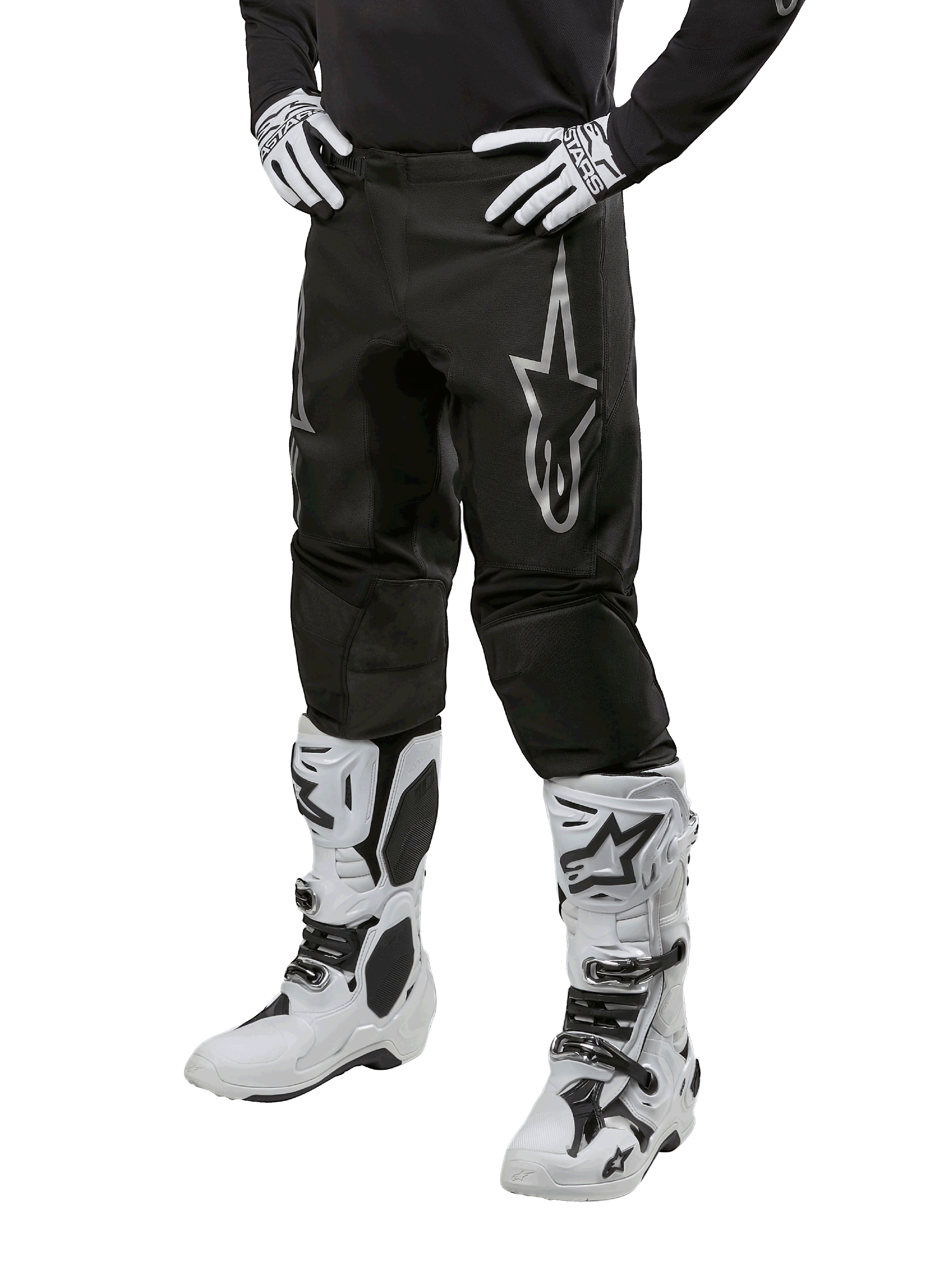 Alpinestars 2024 Fluid Graphite Pants, Motocross Pants, Black and Silver, featuring a silver Alpinestars logo on the thigh, shown worn with white motocross boots and gloves, designed for off-road motorcycle racing