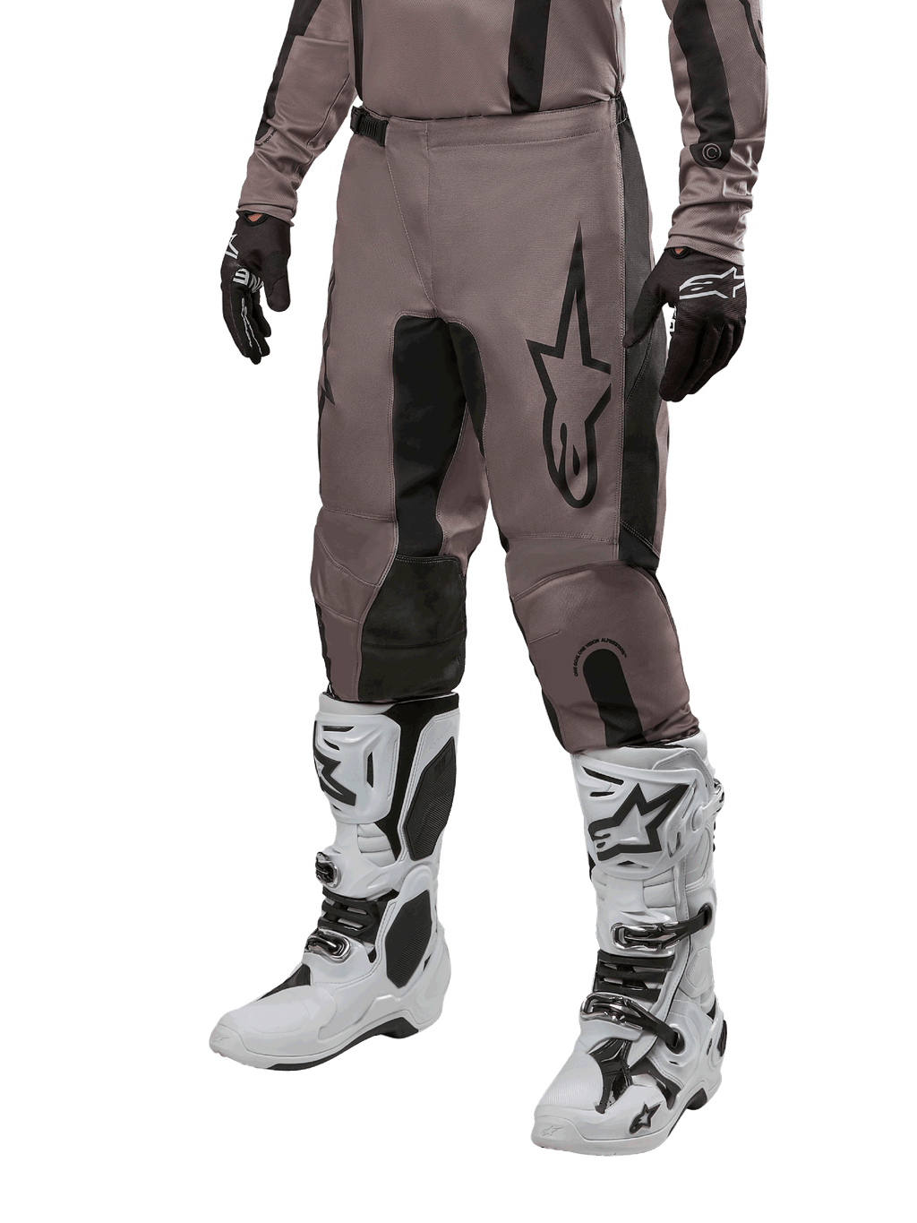 Alpinestars 2024 Fluid Lurv Pants, pantalon de motocross, Mud Black et noir, avec logo Alpinestars, porté avec gants noirs et bottes de motocross blanches, design sportif pour la course tout-terrain