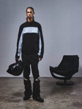 Alpinestars RSRV Track Jacket, veste de survêtement noire et grise avec logo étoile, portée avec un casque noir assorti, style streetwear premium inspiré du sport automobile