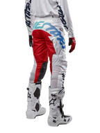 Alpinestars Racer Hana Pants 2024, pantalon de motocross, blanc multicolore avec des accents rouges et bleus, vue arrière montrant un marquage important sur l'assise, porté avec des bottes de motocross blanches et noires, conçu pour la performance et la durabilité en tout-terrain