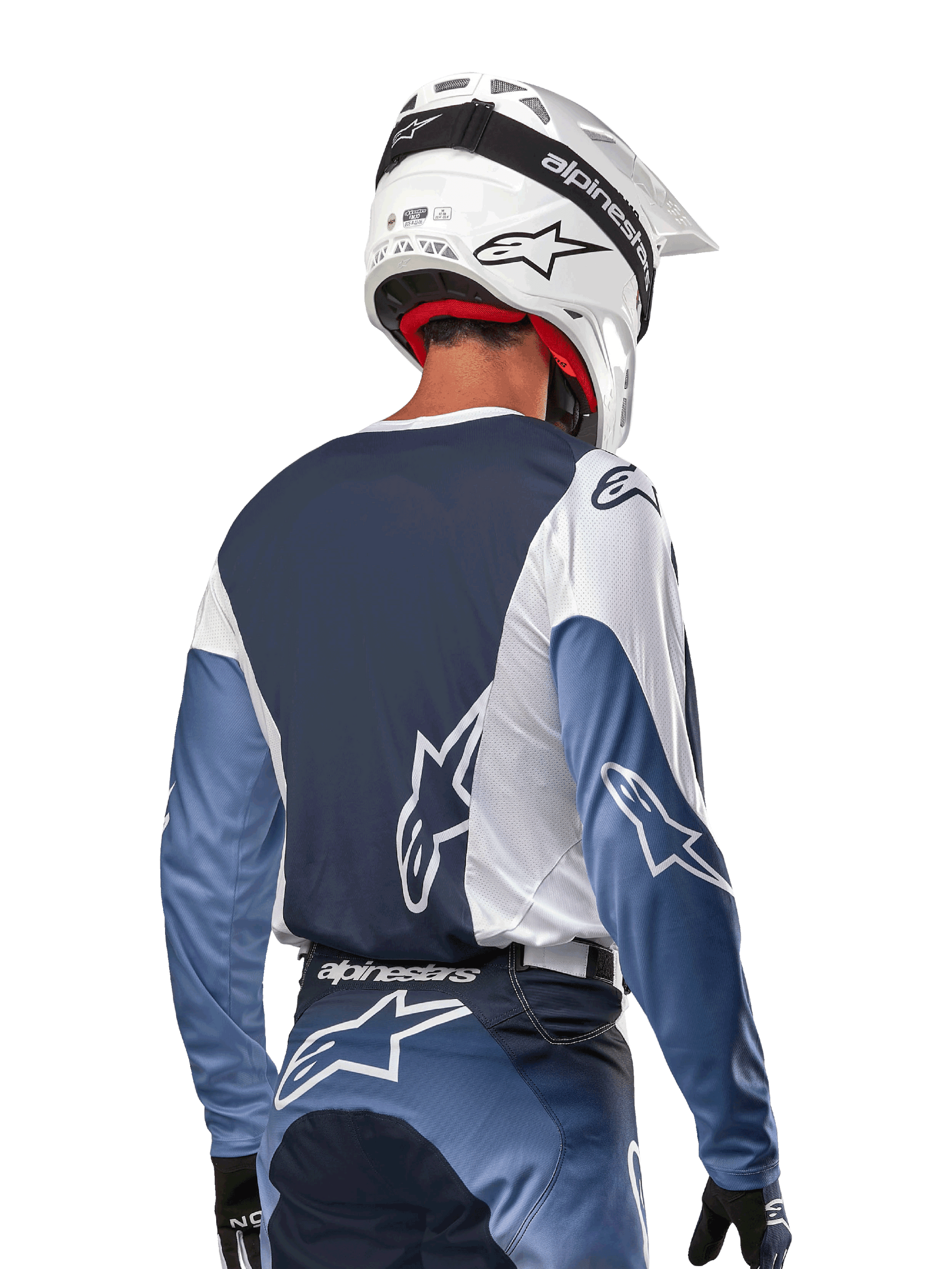 Alpinestars 2024 Racer Hoen Jersey, maillot de motocross blanc, bleu marine et bleu clair, vue de dos d'un pilote avec casque blanc, design ergonomique et technique pour le tout-terrain.