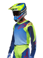 Alpinestars 2024 Racer Hoen Jersey, Motocross Jersey, Yellow Fluo and Blue Night Navy with red logos, worn with a matching yellow, blue, and red helmet and blue gloves, vibrant gear for off-road racing