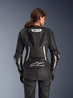 Alpinestars Stella GP-R7 2-Piece Leather Suit, combinaison de moto pour femme, noire avec accents blancs, vue de dos montrant la bosse aérodynamique Supertech R10 avec logo GP-R7, marquage Tech-Air Ready sur le bas du dos, lettrage Alpinestars blanc sur les manches et panneaux extensibles en accordéon pour la performance en course