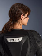Combinaison en cuir 2 pièces Alpinestars Stella GP-R7, noir, vue rapprochée du dos présentant le logo GP-R7 sur la bosse aérodynamique, panneaux extensibles en cuir accordéon sur les épaules, construction de qualité course pour femme.