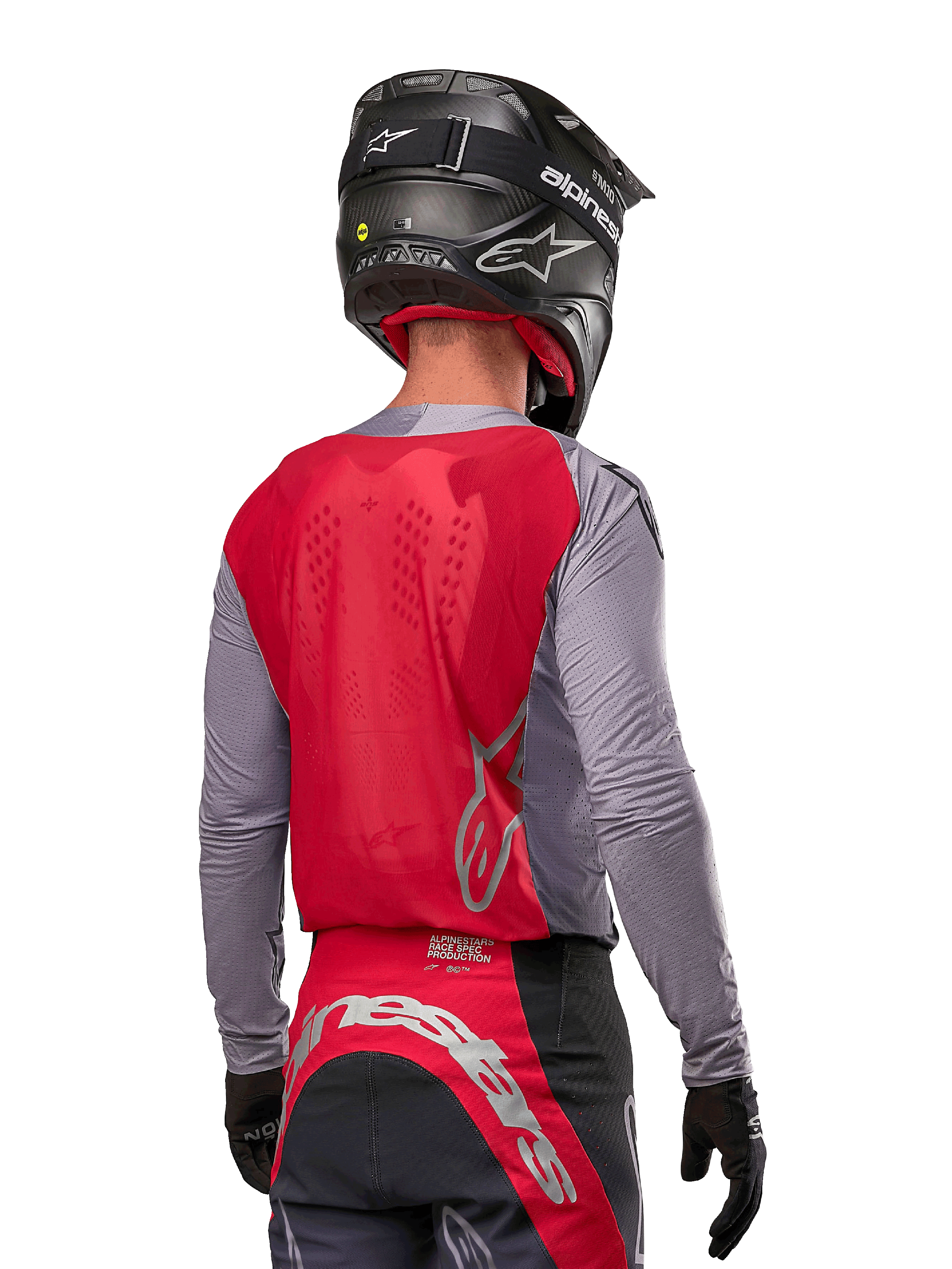Pilote de motocross de dos portant le maillot Alpinestars 2024 Supertech Dade en Iron Red Berry et gris, doté d'un panneau arrière en mesh respirant et de logos argentés, associé à un casque noir et un pantalon de course assorti pour une performance tout-terrain professionnelle.