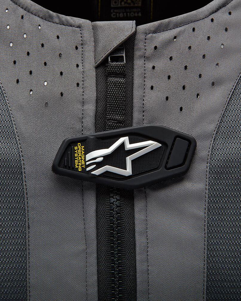 Système Airbag Alpinestars Tech-Air 5, rabat magnétique avec logo étoile blanc sur tissu gris perforé.