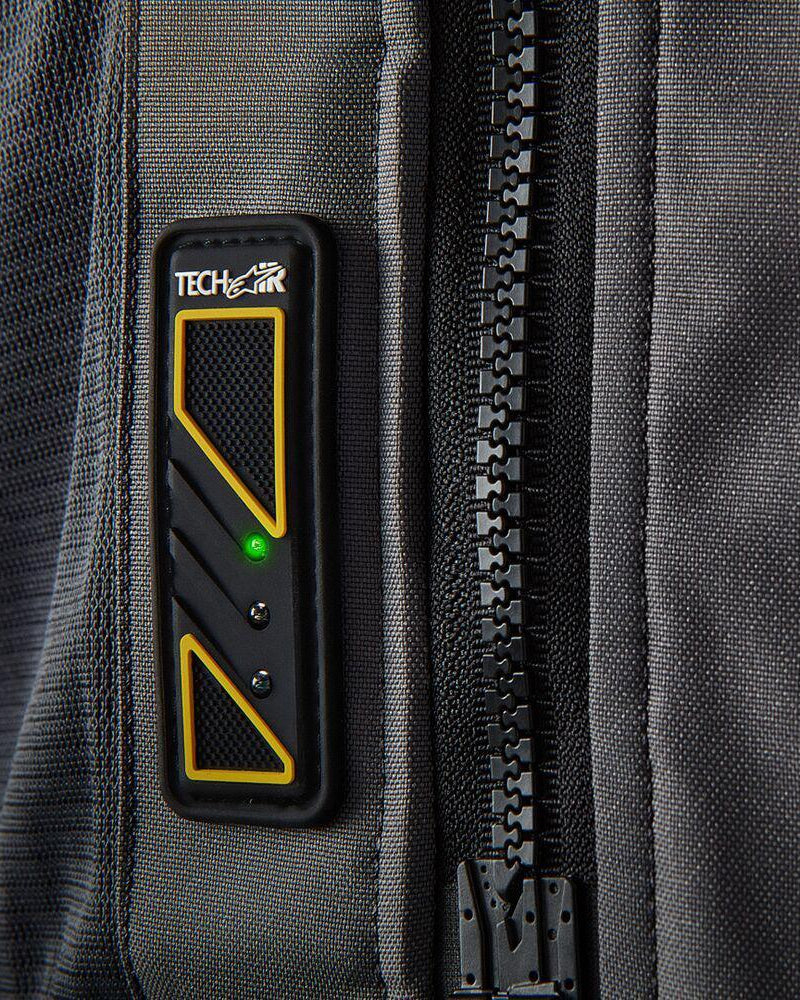 Affichage Led Alpinestars Tech-Air 5 sur gilet textile gris foncé, voyant vert et fermeture éclair noire.