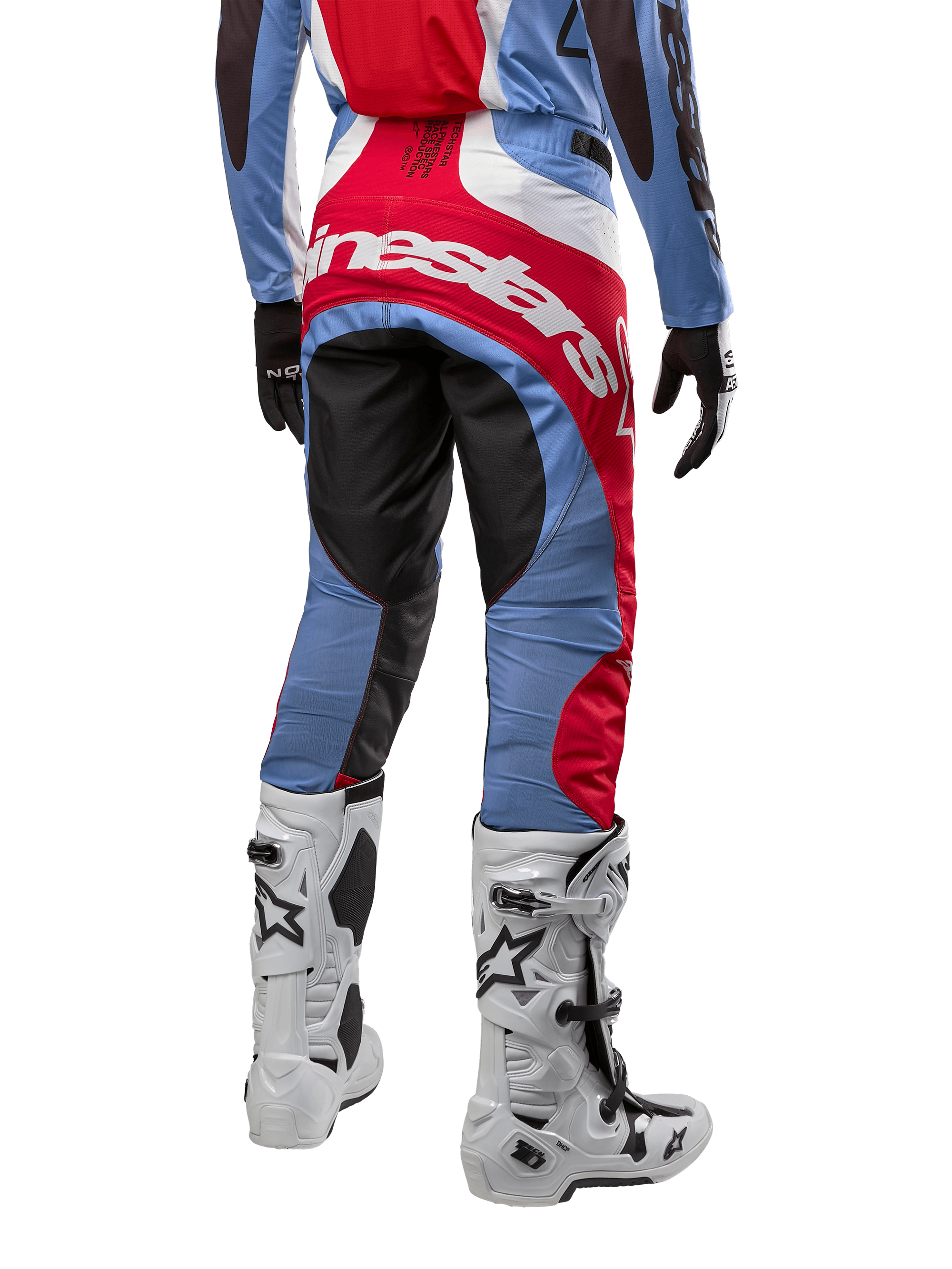 Alpinestars 2024 Techstar Ocuri Pants, pantalon de motocross, bleu clair, rouge Mars et blanc, vue arrière mettant en évidence le grand logo Alpinestars rouge sur l'assise, porté avec des bottes de course blanches et un maillot assorti.