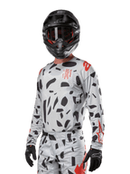 Alpinestars 2024 Techstar Rantera Jersey, Motocross Jersey, Haze Gray Camo with black abstract patterns and red accents, long-sleeve design worn with matching black helmet and gloves, technical off-road racing gear