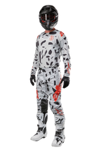 Alpinestars 2024 Techstar Rantera Pants, Motocross Pants, Haze Gray Camo, worn with matching jersey, black helmet, and white and black boots, featuring black abstract patterns and red accents, complete off-road racing gear