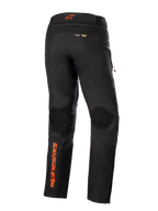 Pantalon Alpinestars AMT-10R Drystar® XF, noir avec accents orange, vue arrière montrant le logo Alpinestars vertical orange sur la jambe gauche, des empiècements texturés aux genoux et les marquages Kevlar et Matryx, pantalon technique de moto pour l'aventure touring.