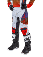 Alpinestars Pantalon Racer Hoen Junior 2024, pantalon de motocross, gris clair avec accents orange vif et noirs, avec logos étoiles rouges sur les cuisses et panneaux rouges aux genoux, porté avec des bottes noires et blanches, conception durable pour le tout-terrain