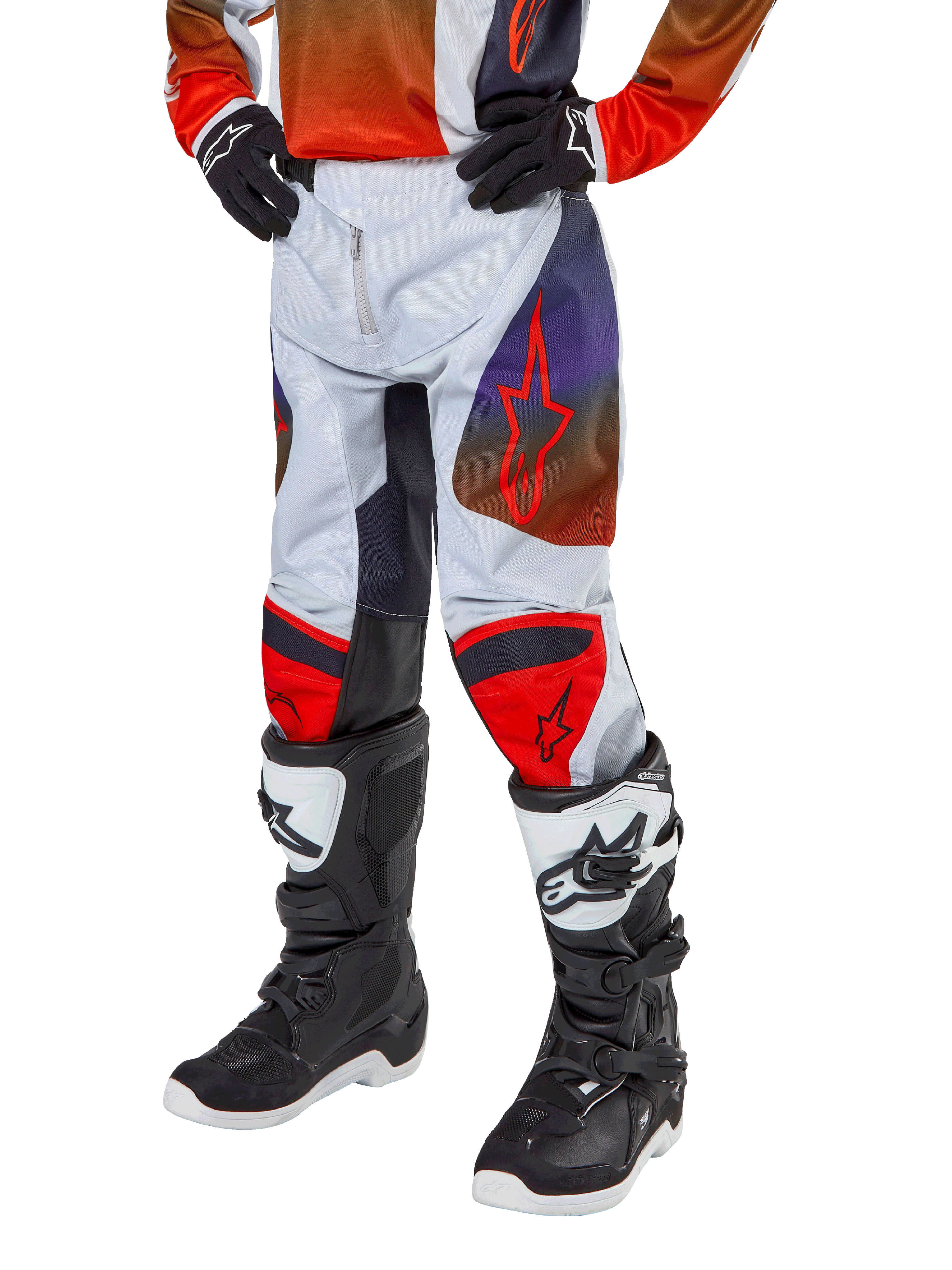 Alpinestars Pantalon Racer Hoen Junior 2024, pantalon de motocross, gris clair avec accents orange vif et noirs, avec logos étoiles rouges sur les cuisses et panneaux rouges aux genoux, porté avec des bottes noires et blanches, conception durable pour le tout-terrain