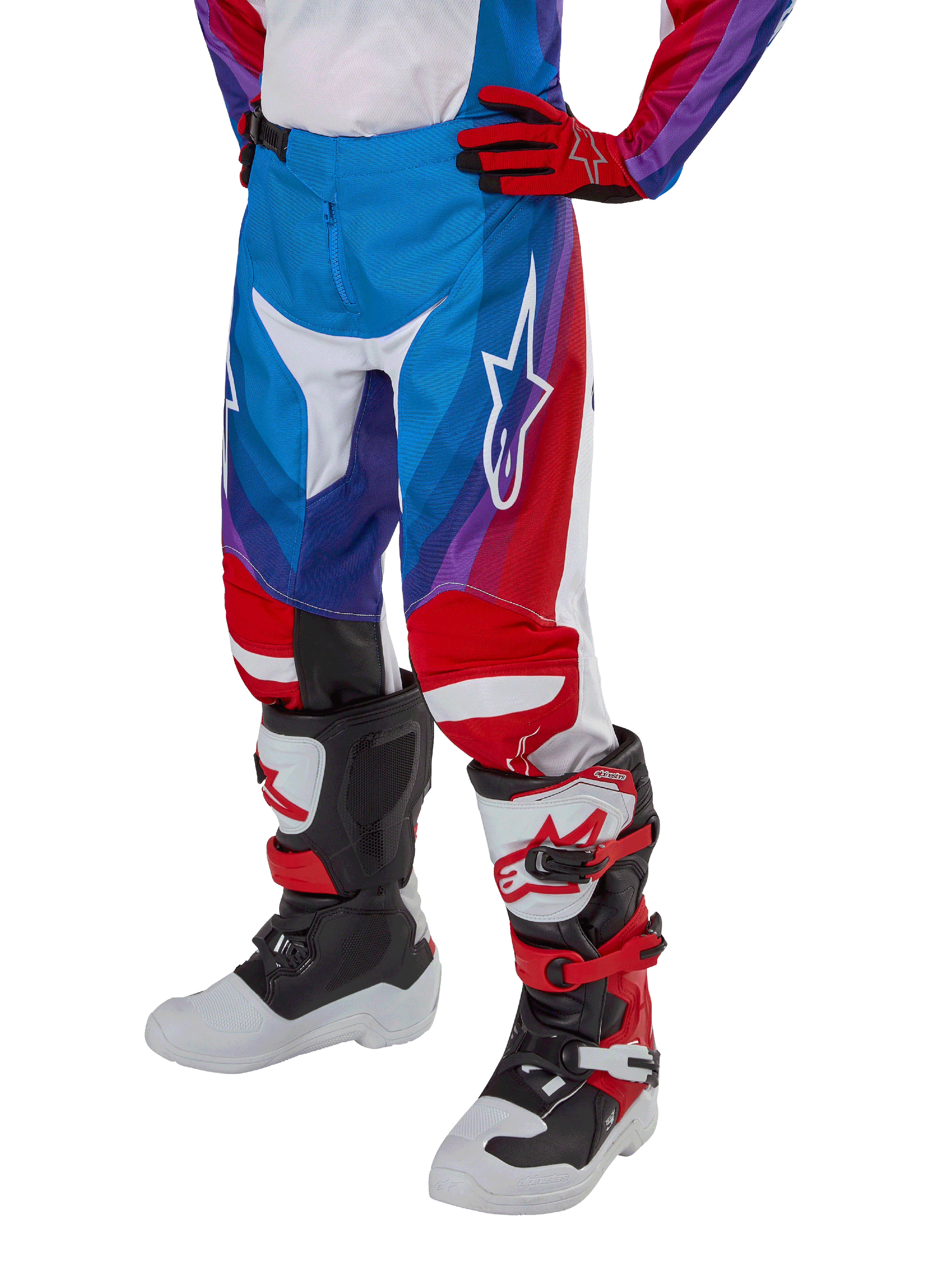 Alpinestars Youth 2024 Racer Pneuma Pants, pantalon de motocross, bleu, rouge et blanc, porté avec des gants et des bottes assortis, avec un logo étoile blanc sur la cuisse, design sportif pour le tout-terrain