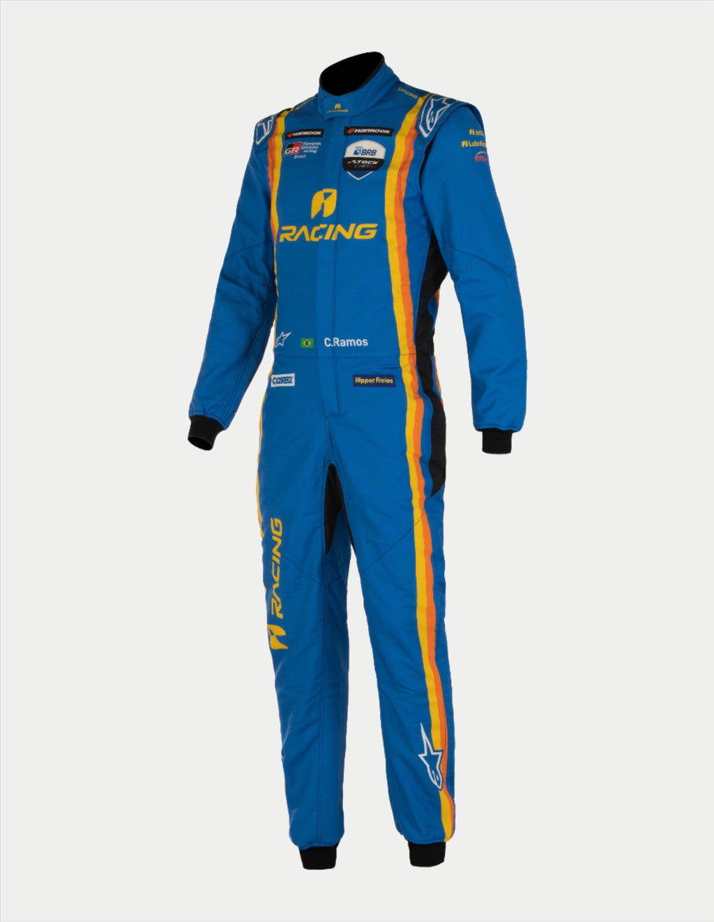 Alpinestars Tech Vision V3 Custom Suit, combinaison de course automobile professionnelle, bleue avec bandes jaunes et orange, logos de sponsors et personnalisation « C. Ramos », construction légère en Nomex avec poignets noirs