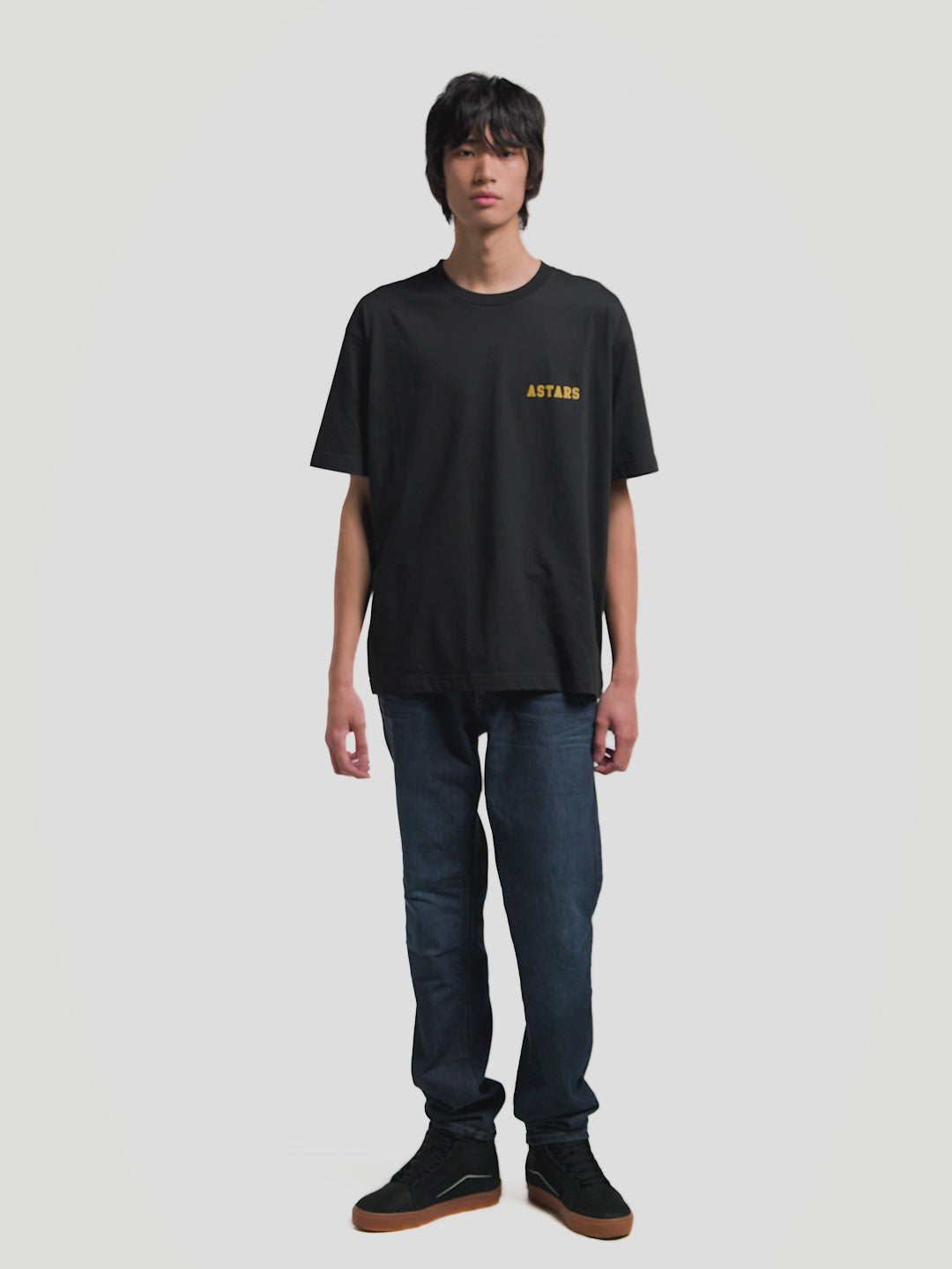 Alpinestars Latitude Oversized CSF Tee, Short Sleeve Sportswear T-shirt, Black with Yellow and Green graphics, featuring a front yellow ASTARS wordmark and a back globe grid graphic with One Goal One Vision slogan, oversized relaxed fit, premium cotton-poly blend for everyday casual wear.