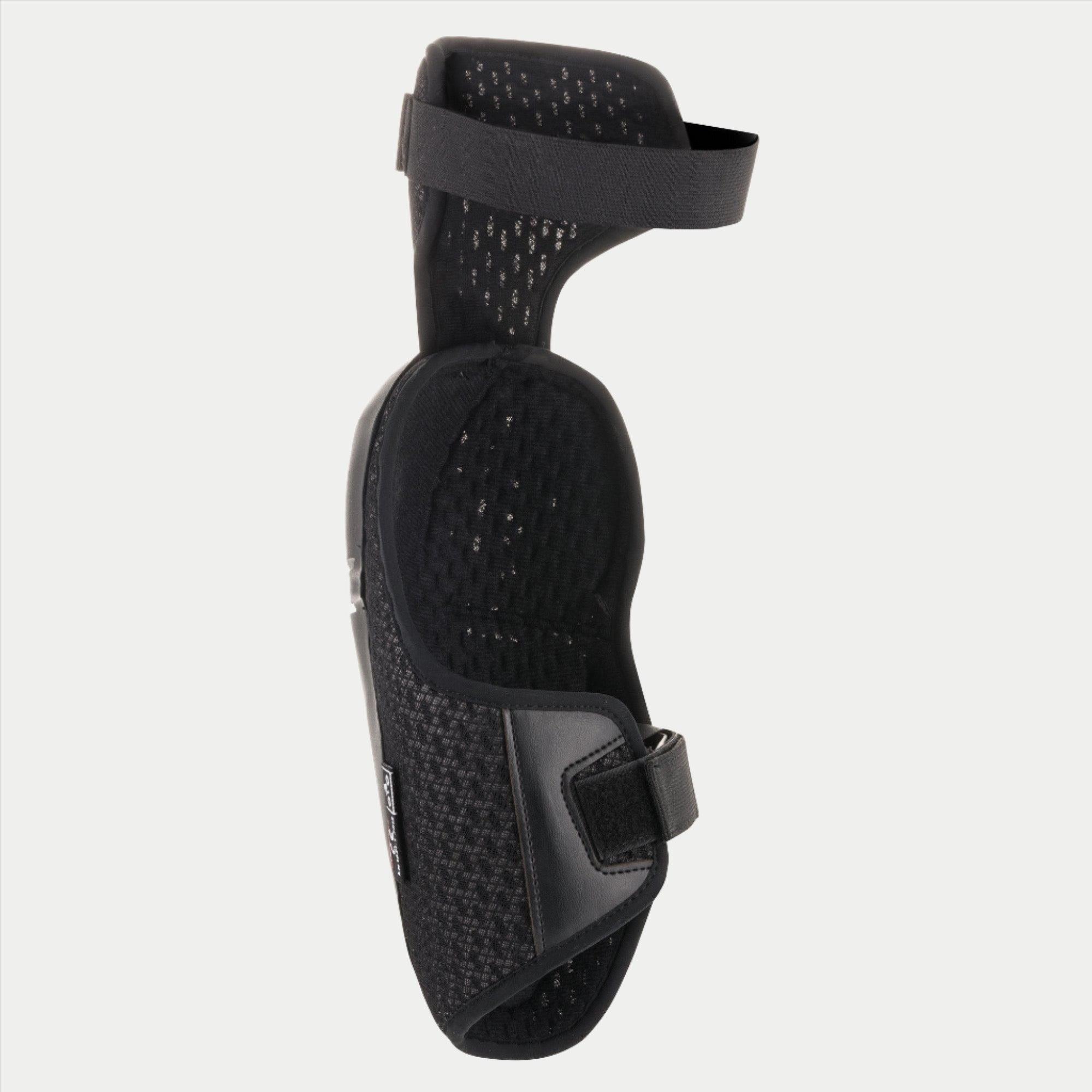 Alpinestars Youth Bionic Plus Knee Protector, noir, illustrant la doublure intérieure en mesh et le système de fermeture à double sangle, conception ergonomique pour la protection motocross tout-terrain